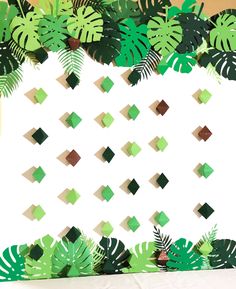 an image of a wall made out of paper with green leaves and squares on it