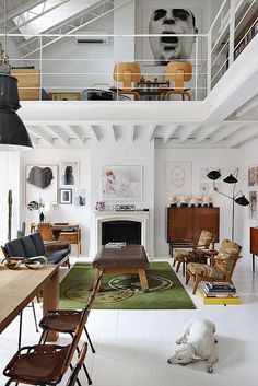 a living room filled with furniture and a fire place next to a dining room table