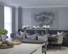 a living room filled with furniture and flowers in vases on top of a table