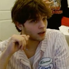 a young man sitting in front of a laptop computer