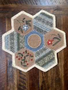 a close up of a piece of cloth on a wooden floor with flowers and leaves