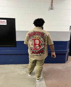 a man in a jail cell wearing a shirt with the number 98 on it and holding his hand out