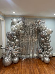 a room decorated with silver balloons and star decorations