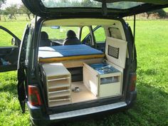 the back end of a vehicle with an open hatchback door and shelves in it