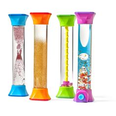 three different colored plastic tubes with sand in them