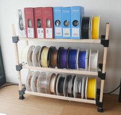 a shelf filled with different types of spools of thread and pla discs