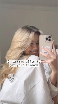 a woman holding up her cell phone to take a selfie with the caption, christmas gifts to get your friends