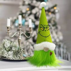 a green elf hat sitting on top of a table next to a candelabra