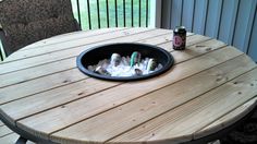 a wooden table topped with lots of bottles and cups on top of it next to a deck