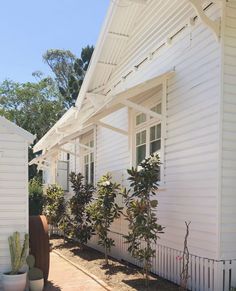 a white house with plants in front of it