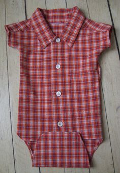 a red and white plaid shirt laying on top of a wooden floor