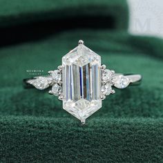 an emerald cut diamond ring with three diamonds on it