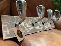 four golf clubs are hanging on a wooden holder with a price tag attached to it