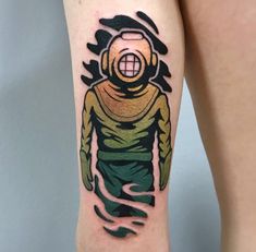 a person with a tattoo on their leg that has an image of a man in a diving suit