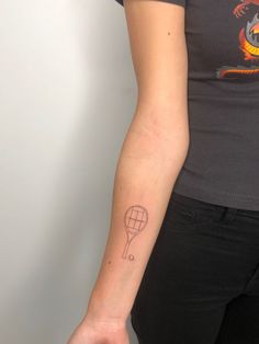 a woman with a tattoo on her arm holding a tennis racquet and ball