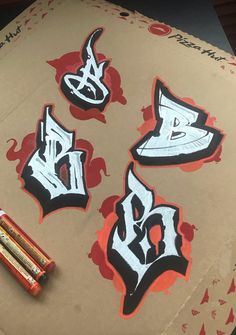 some type of graffiti stickers on top of a piece of cardboard with crayons