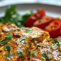 a white plate topped with chicken covered in sauce and garnished with parsley