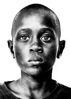 a black and white photo of a young man with freckles on his face