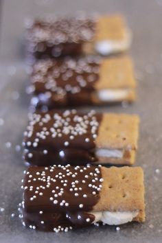 some kind of cracker with chocolate and marshmallows on top, along with white sprinkles