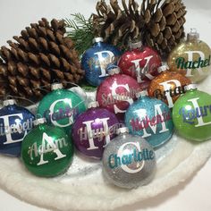 christmas ornaments with letters and pine cones on a plate