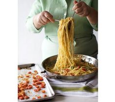 a woman is eating spaghetti from a pan