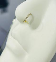 a diamond ring sitting on top of a white mannequin's dummy head