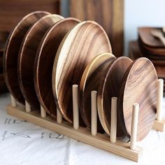 several wooden plates are stacked up on a rack