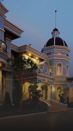 a large building with a clock on the top of it's roof at night