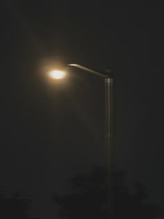 a street light in the dark on a foggy night