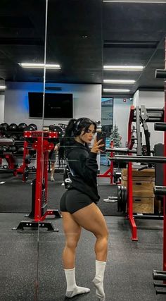 a woman standing in the middle of a gym