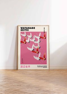 a pink poster with white birds flying in the sky on a shelf next to a vase