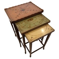 three nesting tables with painted designs on them