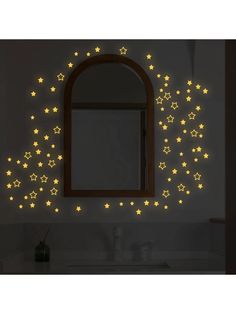 a bathroom wall with stars on it and a mirror above the sink in front of it