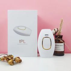 an electronic device sitting on top of a table next to a box and dried flowers