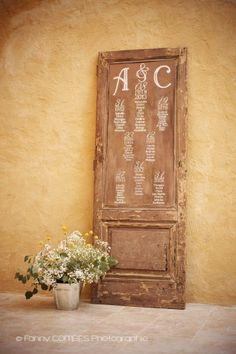 a vase with flowers sitting in front of a sign