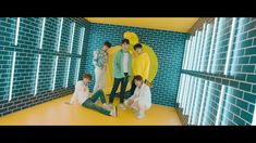 group of people standing in front of blue and yellow tiled walls with one person wearing a banana costume