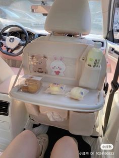 a baby seat in the back of a car with food and drinks on it's tray