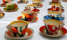 many colorful cups and saucers on a table