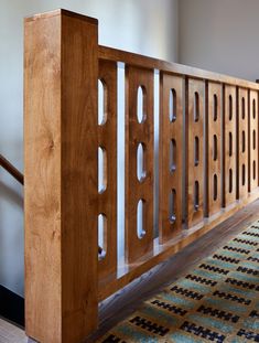 a wooden bench sitting on top of a carpeted floor next to a stair case