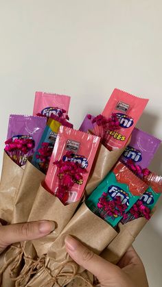 a person holding a bunch of candy in their hands with flowers on the wrapper