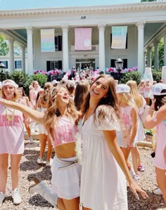 two girls in pink and white dresses are posing for the camera while others look on