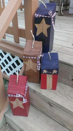 three wooden blocks with stars on them are tied to the porch steps and placed next to each other