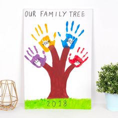 a family tree with handprints on it and a potted plant next to it