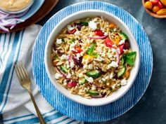 a bowl filled with rice and vegetables next to bowls of fruit