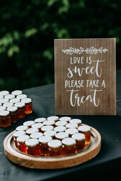 a wooden sign that says love is sweet please take a treat on top of a table