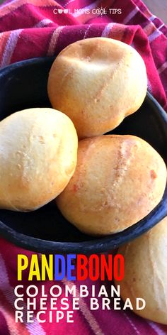 some bread rolls in a black bowl on a red and white towel