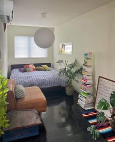 a bed room with a neatly made bed and lots of books