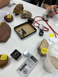 a table topped with lots of different types of rocks and paper on top of it