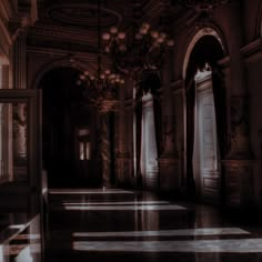 an empty room with columns and chandeliers