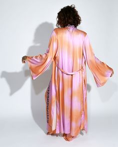 Embrace vibrant elegance with our long kimono and satin pants set. The kimono pairs beautifully with the fluidity of the satin pants, both adorned with a lively pink and orange abstract tie-dye print. Together, they offer a harmonious blend of bohemian charm and contemporary style. Spring Silk Kimono For Loungewear, Silk Kimono For Spring Loungewear, Silk Long Kimono For Loungewear, Spring Satin Kimono For Loungewear, Summer Silk Pink Kimono, Pink Silk Kimono For Spring, Long Pink Silk Robe, Spring Satin Kimono With Kimono Sleeves, Pink Silk Long Sleeve Kimono